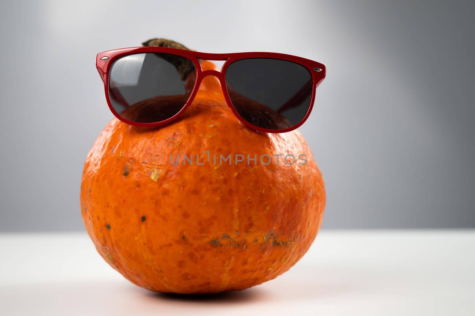 Pumpkin in sunglasses on a white background. Halloween symbol