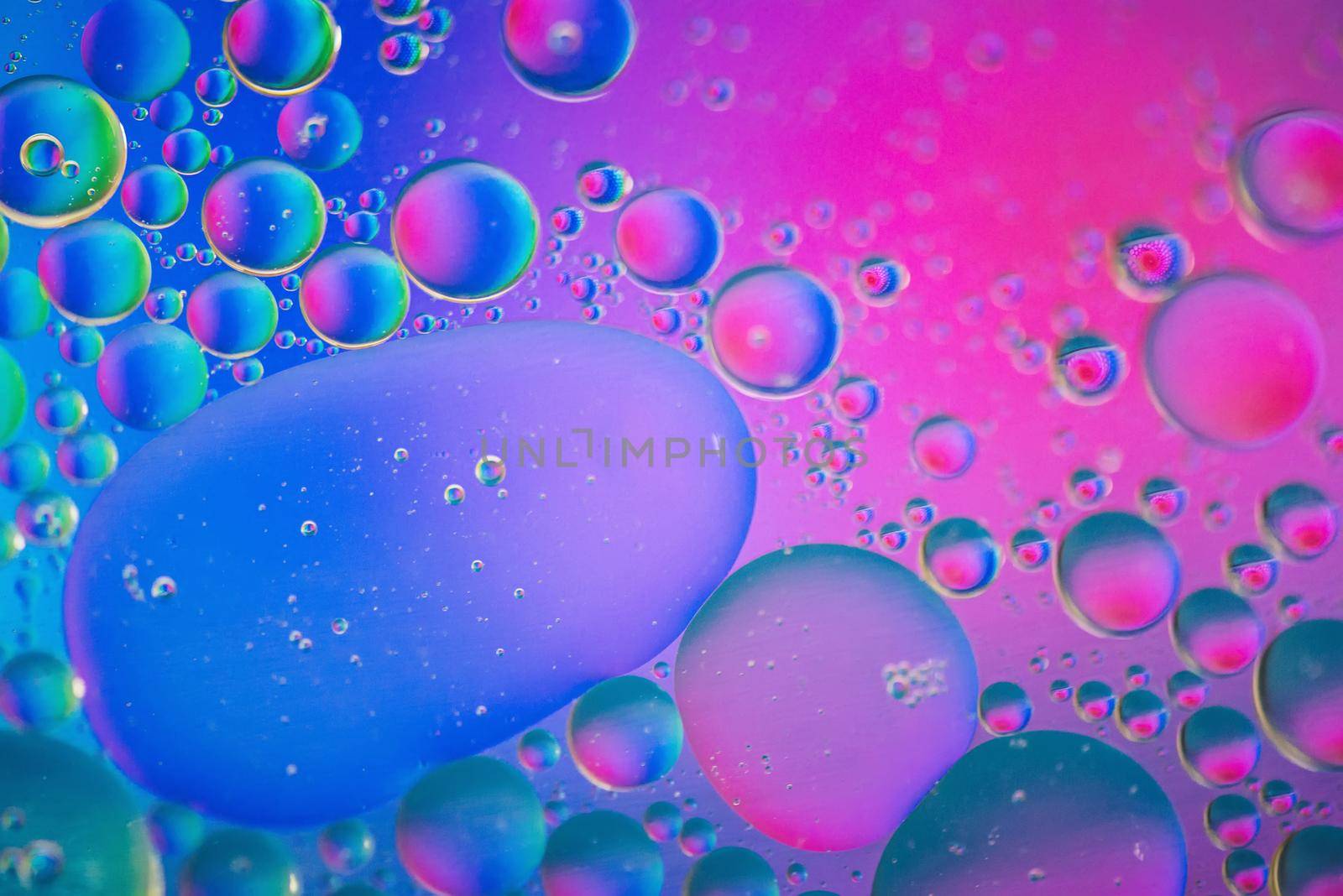Oil drops in water. Defocused abstract psychedelic pattern pink and blue image. Abstract background with colorful gradient colors.