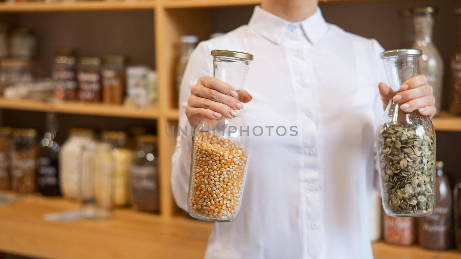 A woman holds two jars of cereals. Eco shop