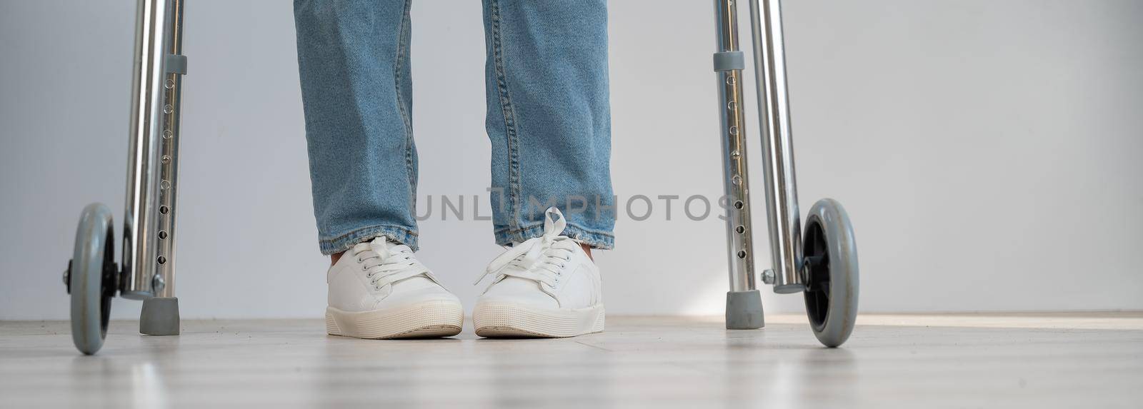 Close-up of female legs with walkers. The girl walks with the help of special equipment. by mrwed54