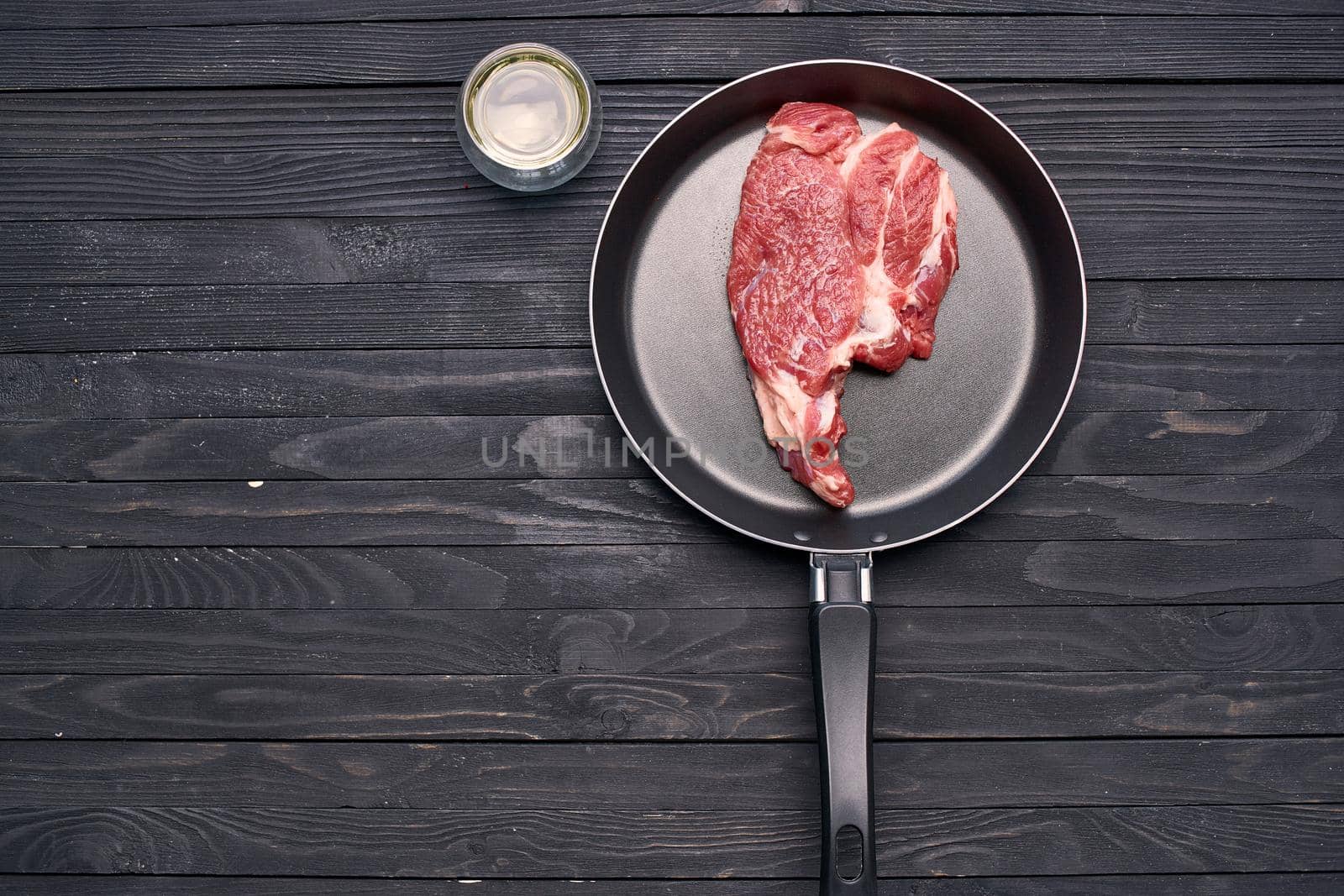 meat steak in a frying pan food ingredients kitchen wooden table by Vichizh