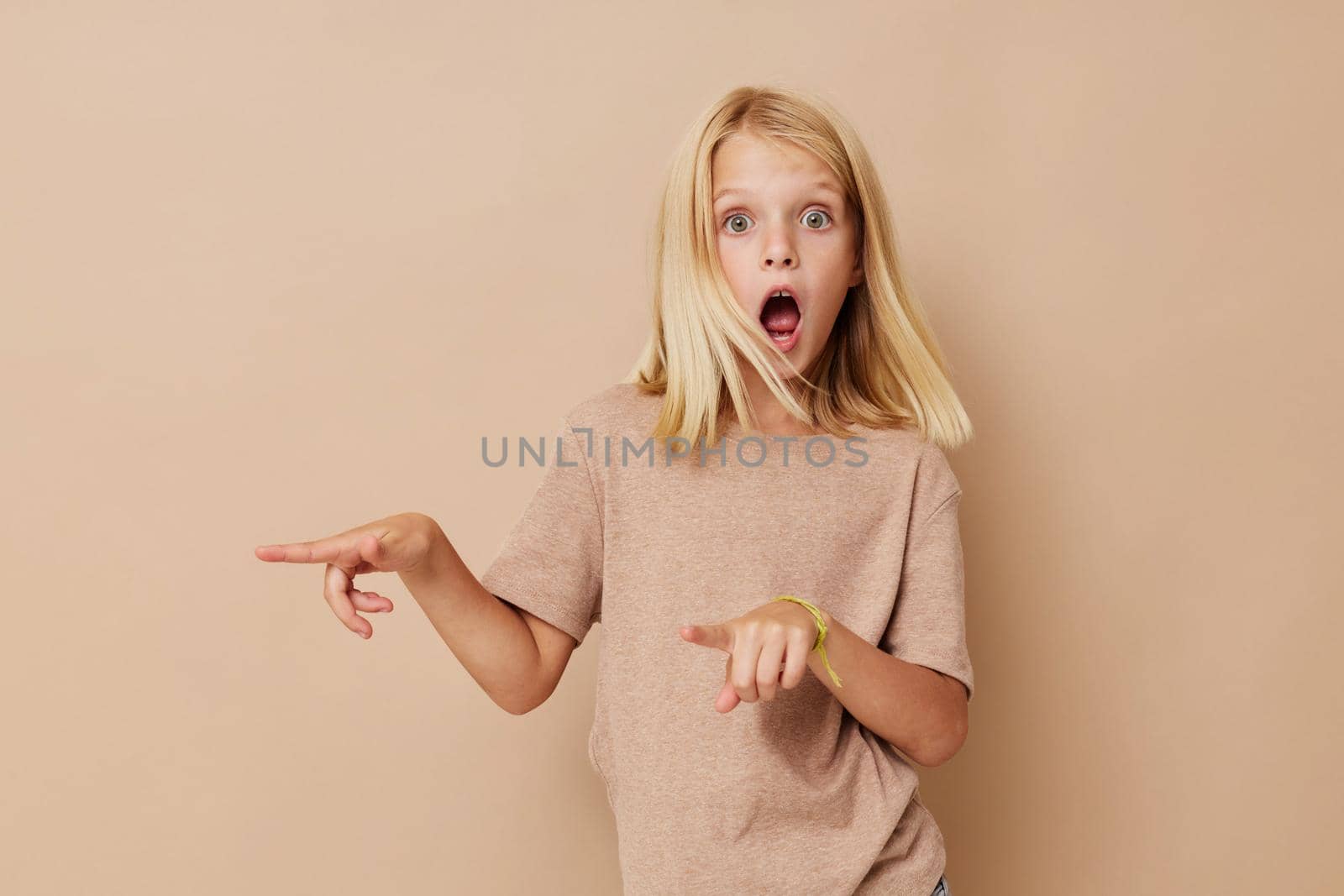 emotional girl with blond hair on a beige background. High quality photo