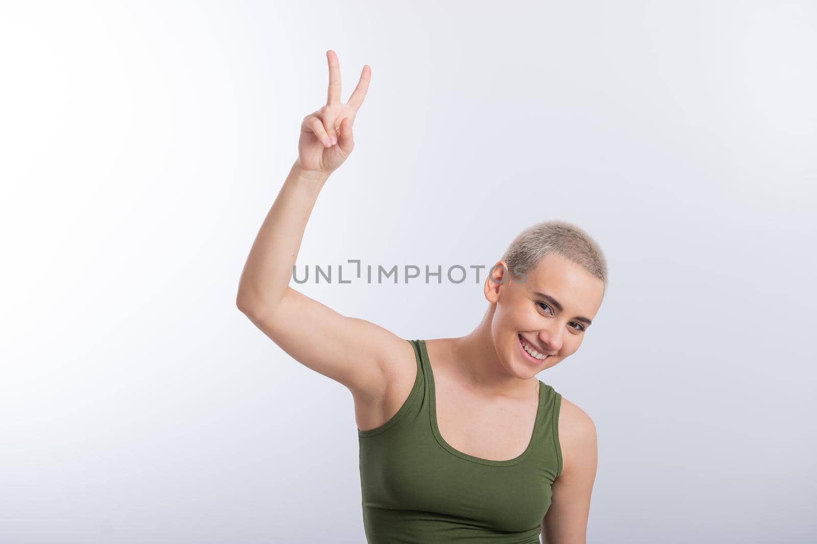 Young Caucasian Woman Holding Raised Hand White Background Smiling Girl Green Tshirt Short Blond Hair