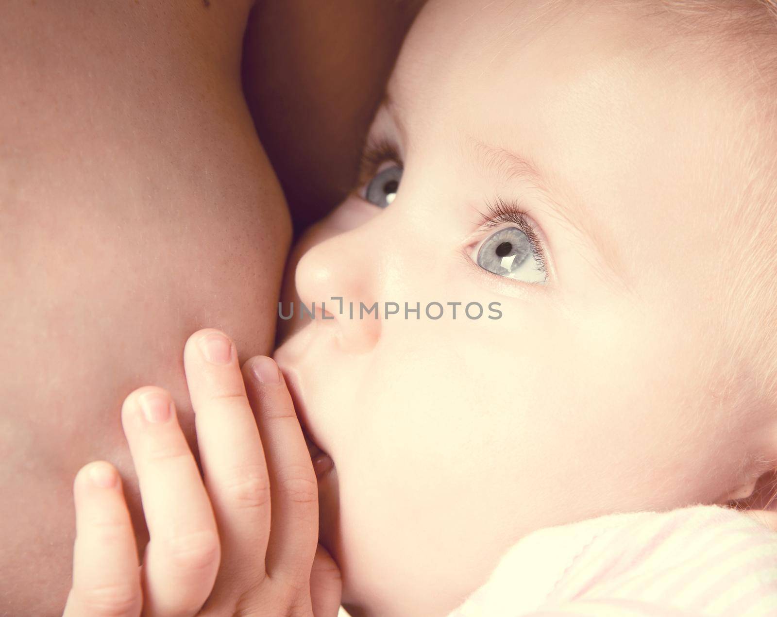 little baby sucking breast mother with open eyes