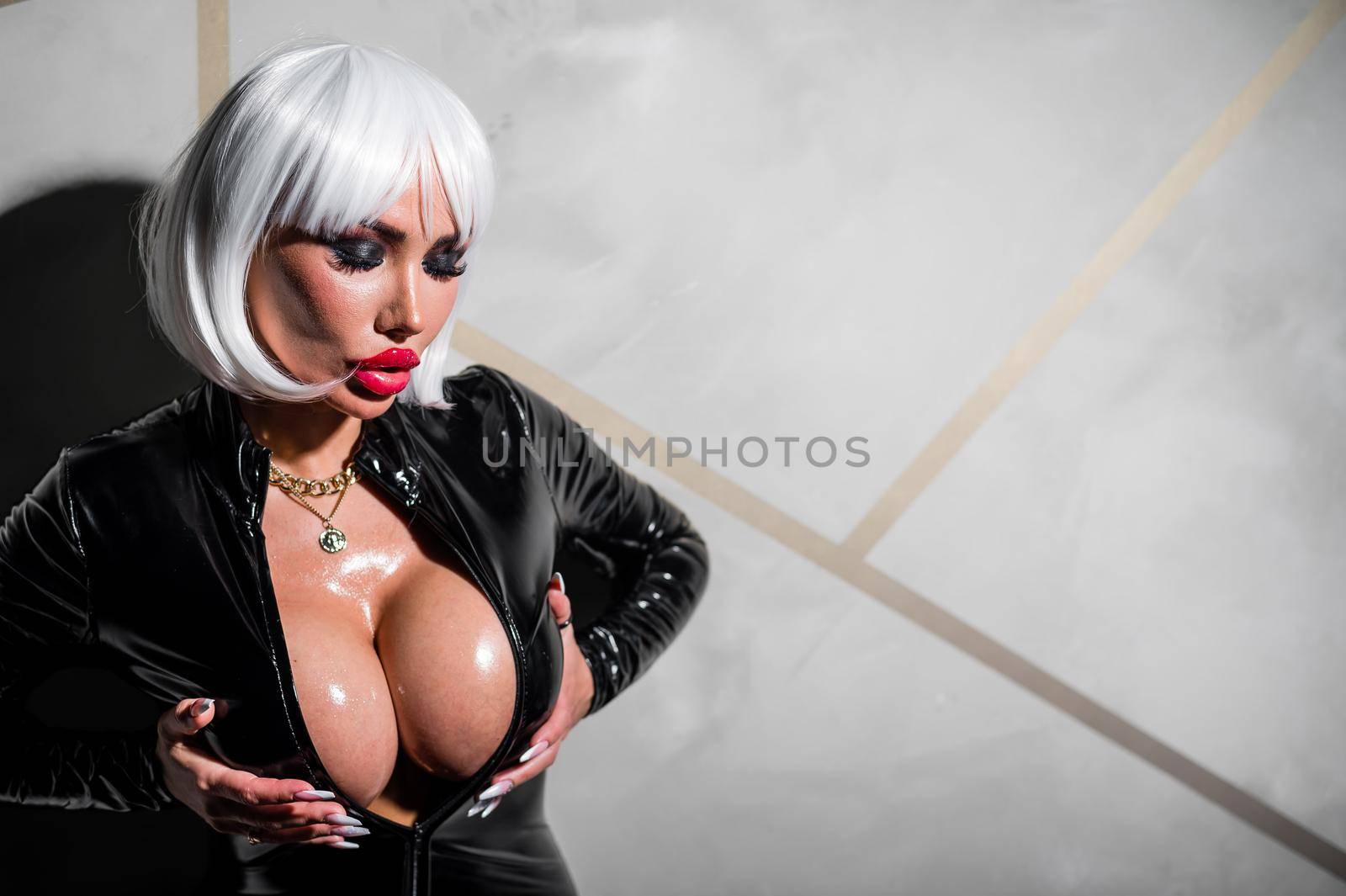 Sexy woman in a blonde wig and latex catsuit. Girl with big fake tits by mrwed54