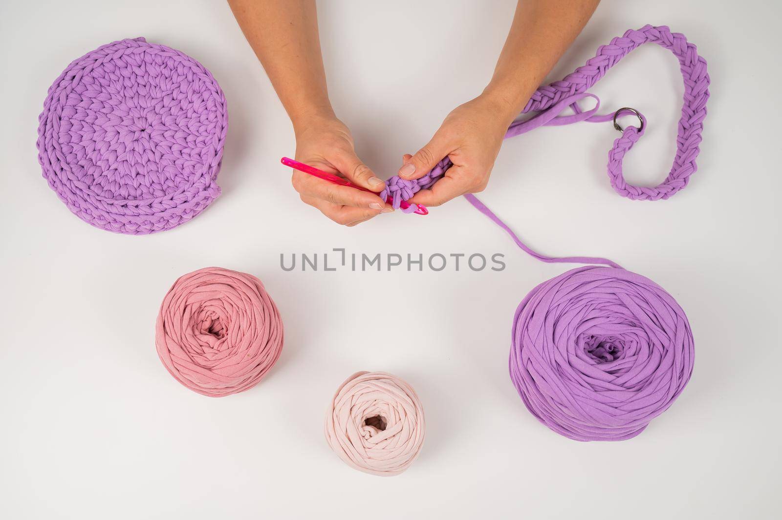 Close-up of a woman crocheting a basket of cotton yarn