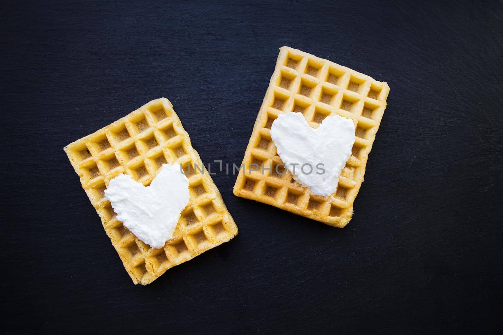 Delicious belgian waffles with cream on a black background