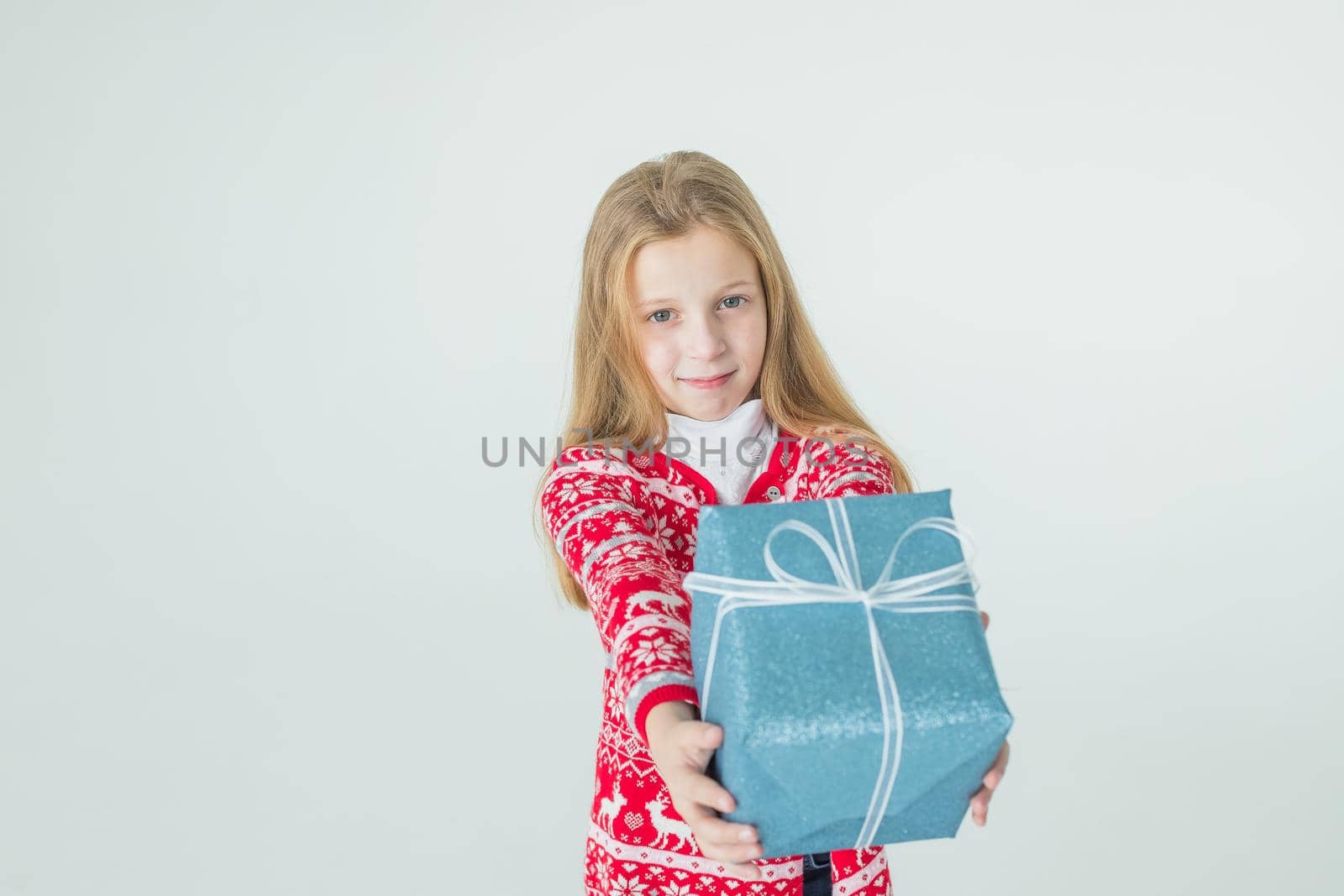 nice girl with Christmas present.Cute kid,child wears red knitted Nordic sweater holding gift, box celebrating. happy 2021 New Year. Merry Christmas presents shopping sale.holidays and people concept by YuliaYaspe1979