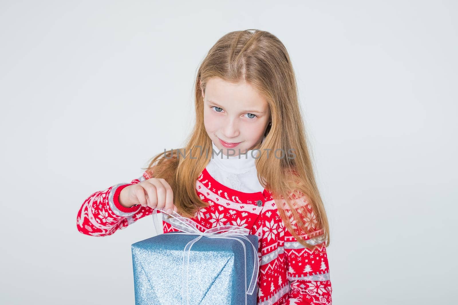 happy little girl with long hair open box with christmas present, isolated on white background.Cheerful handsome girl holding gift with bow in hands and smiling.Copy space by YuliaYaspe1979