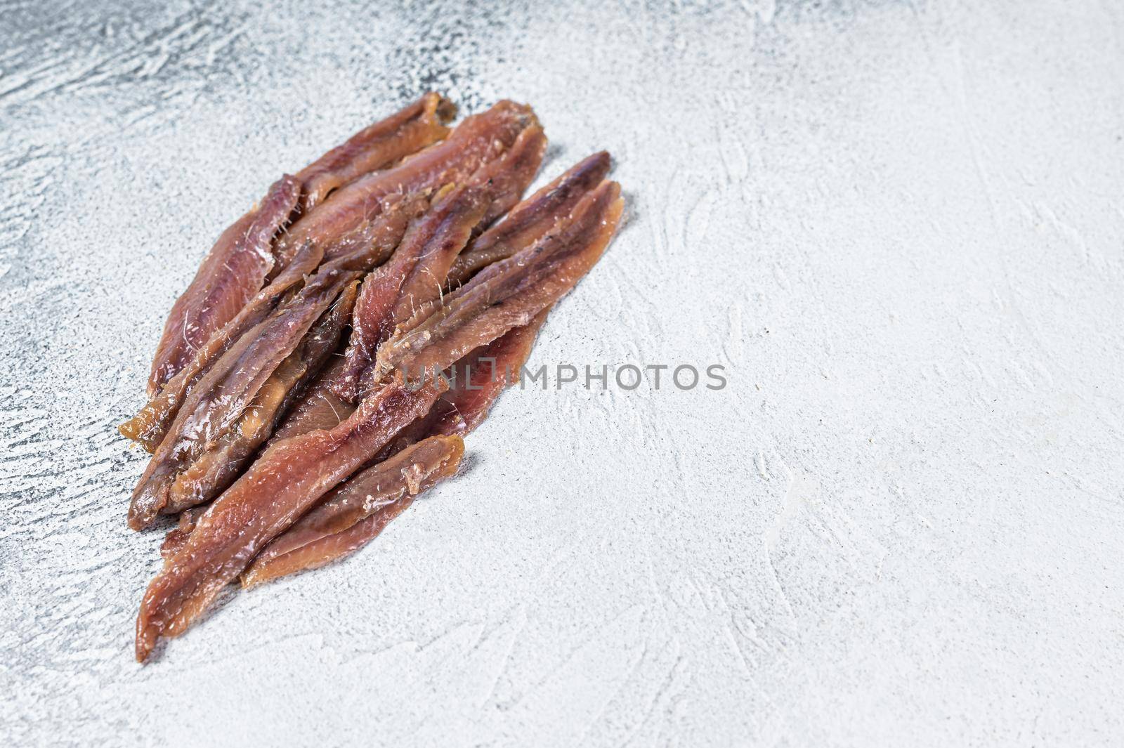 Canned Anchovies fish fillet in Olive Oil. White background. Top view. Copy space.
