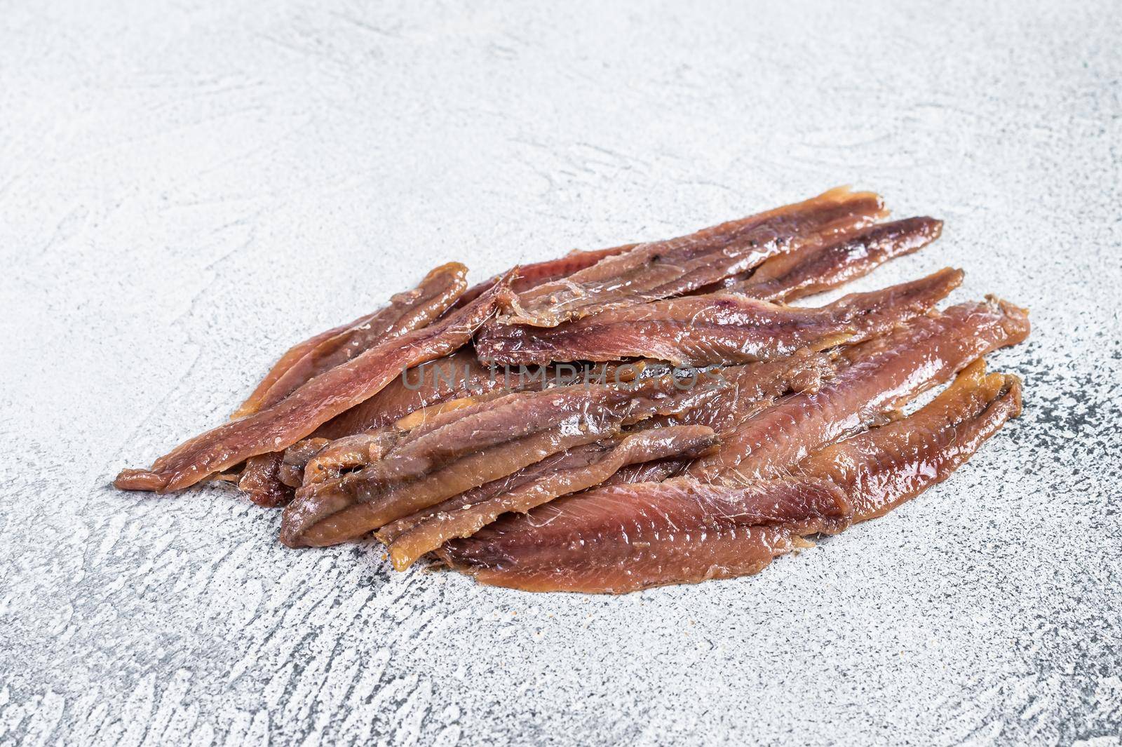 Canned Anchovies fish fillet in Olive Oil. White background. Top view by Composter