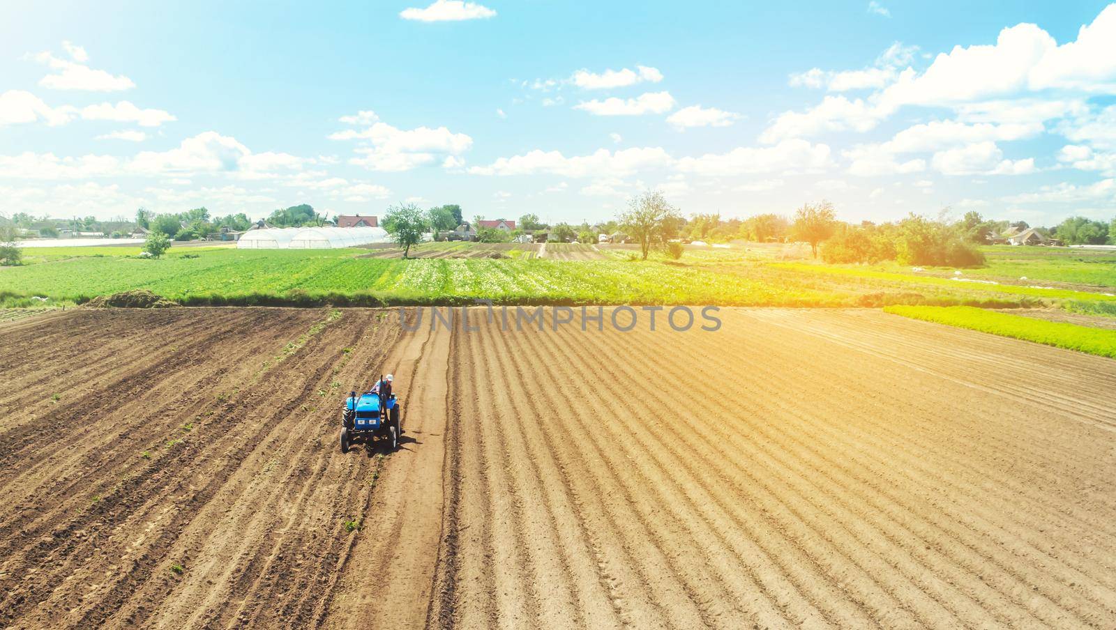Farmer on tractor loosens and grinds the soil. Preparing the land for a new crop planting. Farming and agriculture. agricultural sector of the economy. Loosening the surface, cultivating the land.