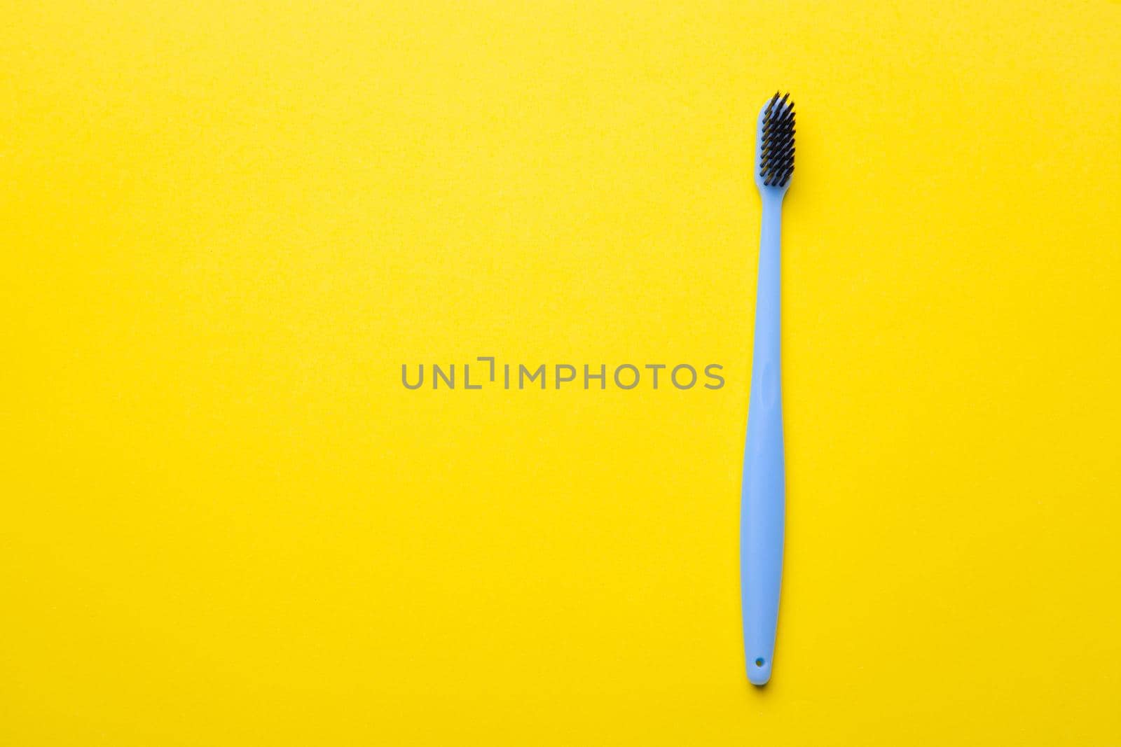 A toothbrush on a yellow background . Silicone toothbrush. Copy space. Yellow background. Dental care. Dentistry. Choosing a toothbrush