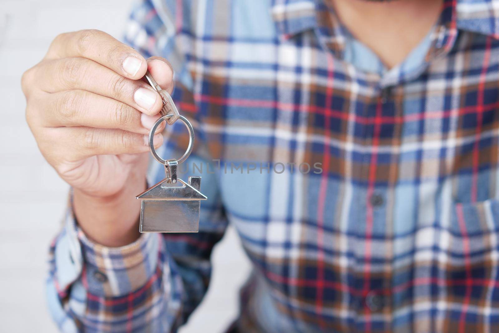 the concept of finance concept , man holding house in hand .