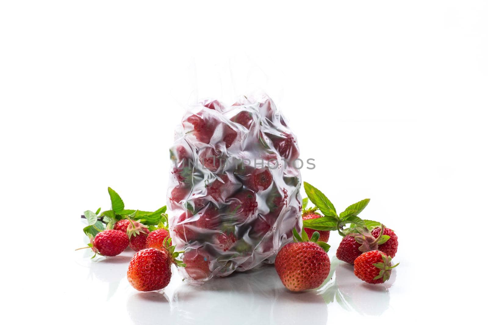 frozen fresh strawberries in a vacuum bag isolated on white background