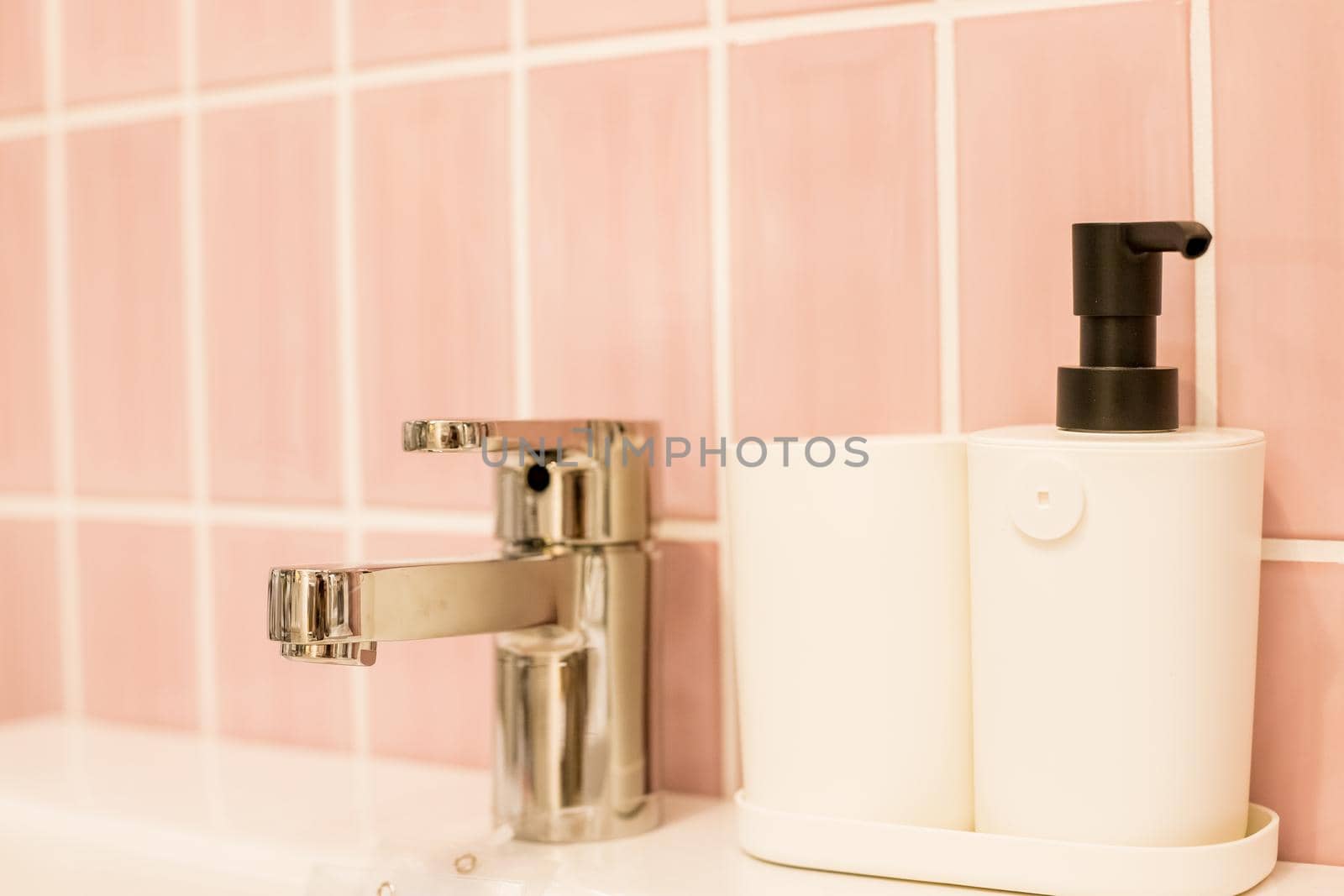 Chrome water faucet with marble counter tops,white sink.Luxury faucet mixer in bathroom. bathtub and water tap. soap in bottle dispenser near silver faucet.Sanitary prevention concept.Selective focus by YuliaYaspe1979