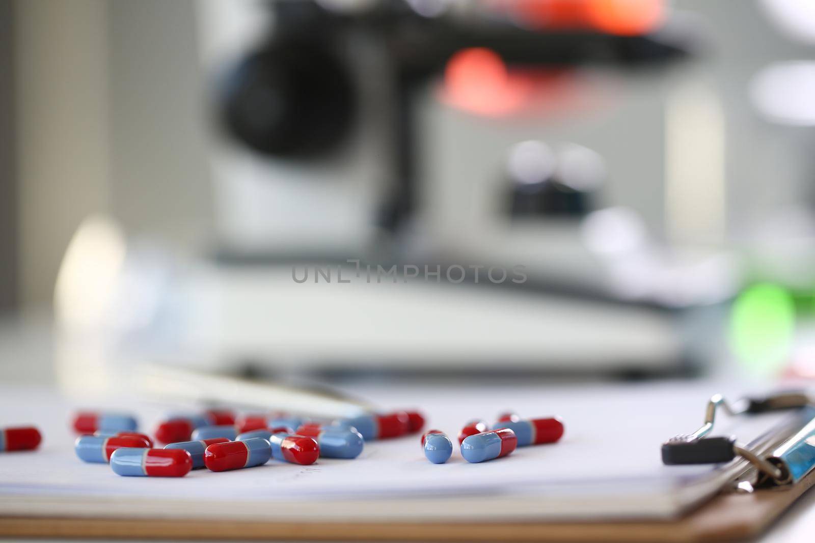 Tablets scattered blue and red color on the table of pharmaceutical laboratory pill for the prescription and treatment various diseases chemistry