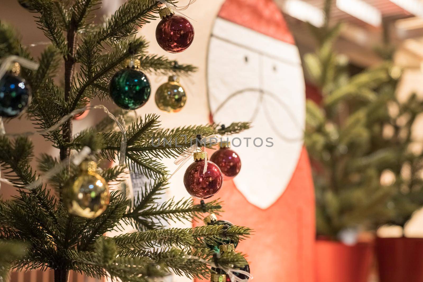 Christmas tree and decorations with snow, blurred, sparking, glowing. Happy New Year. Red and golden balls and illuminated garland with flashlights. New Year baubles on branch. Winter holiday by YuliaYaspe1979