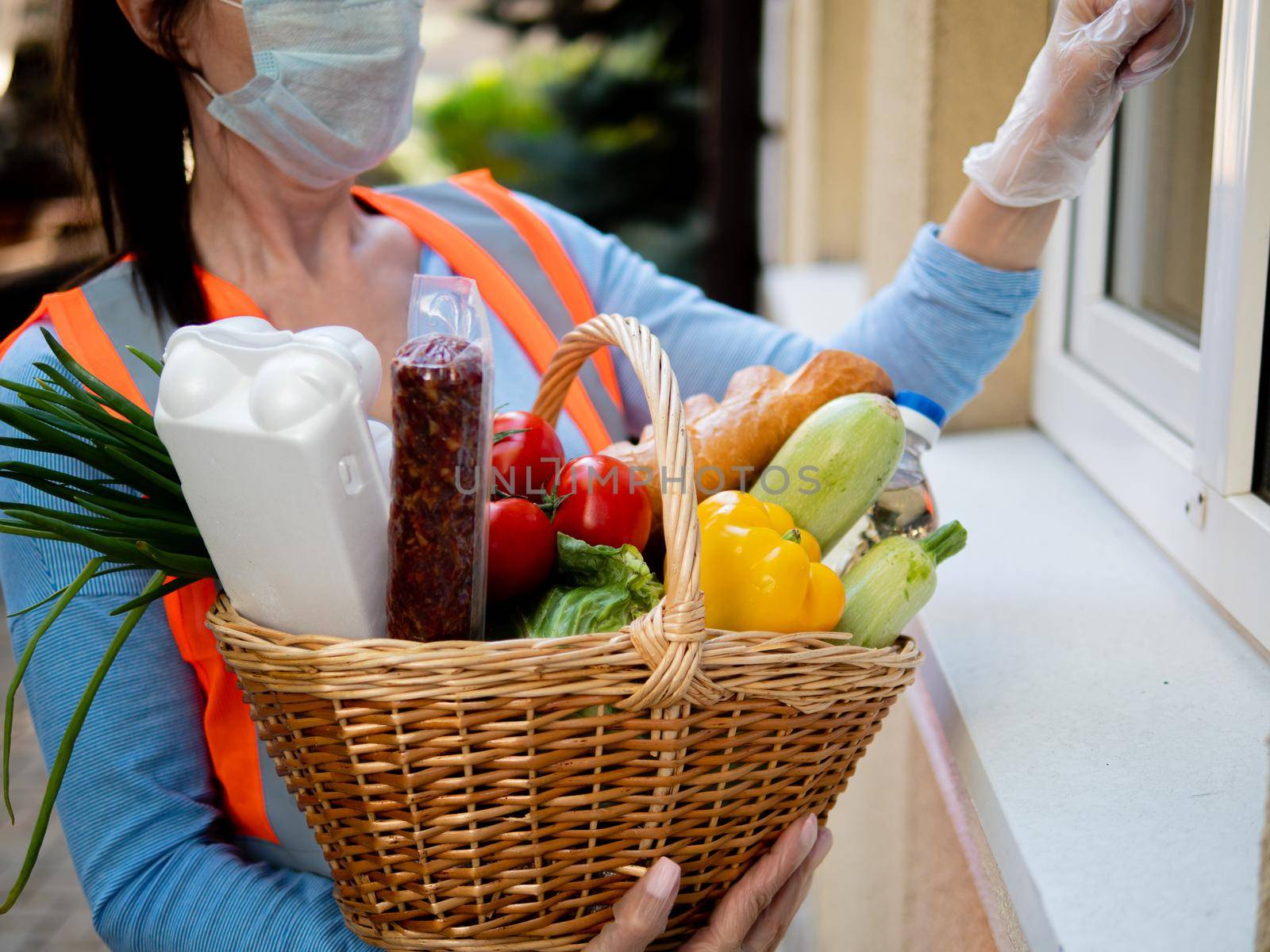 A volunteer deliver fresh food ordered online while in home isolation during quarantine for Covid- 19. Stay home. by Utlanov