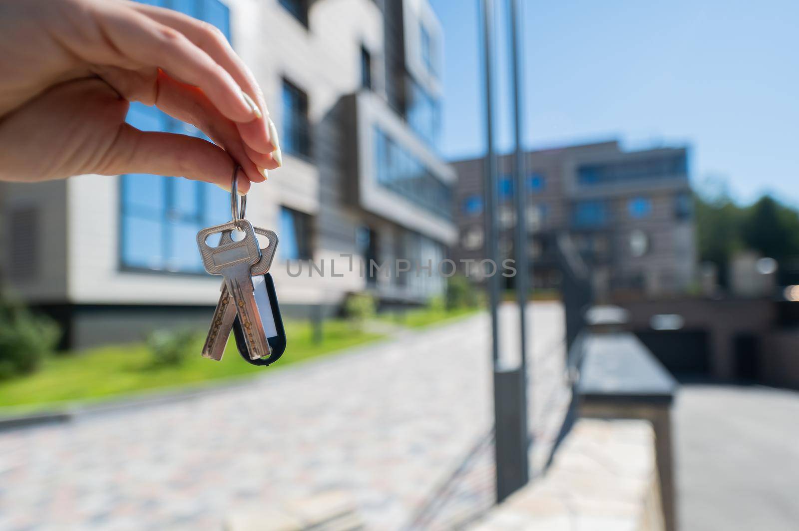 A woman holds the keys to a new house. Close-up of a female hand. Buying a property. by mrwed54