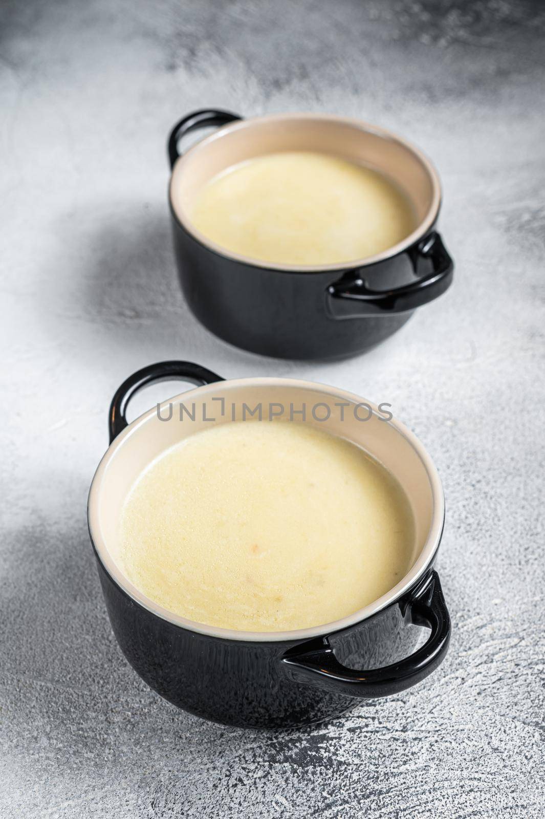 Homemade potato cream soup in bowls. White background. Top view.