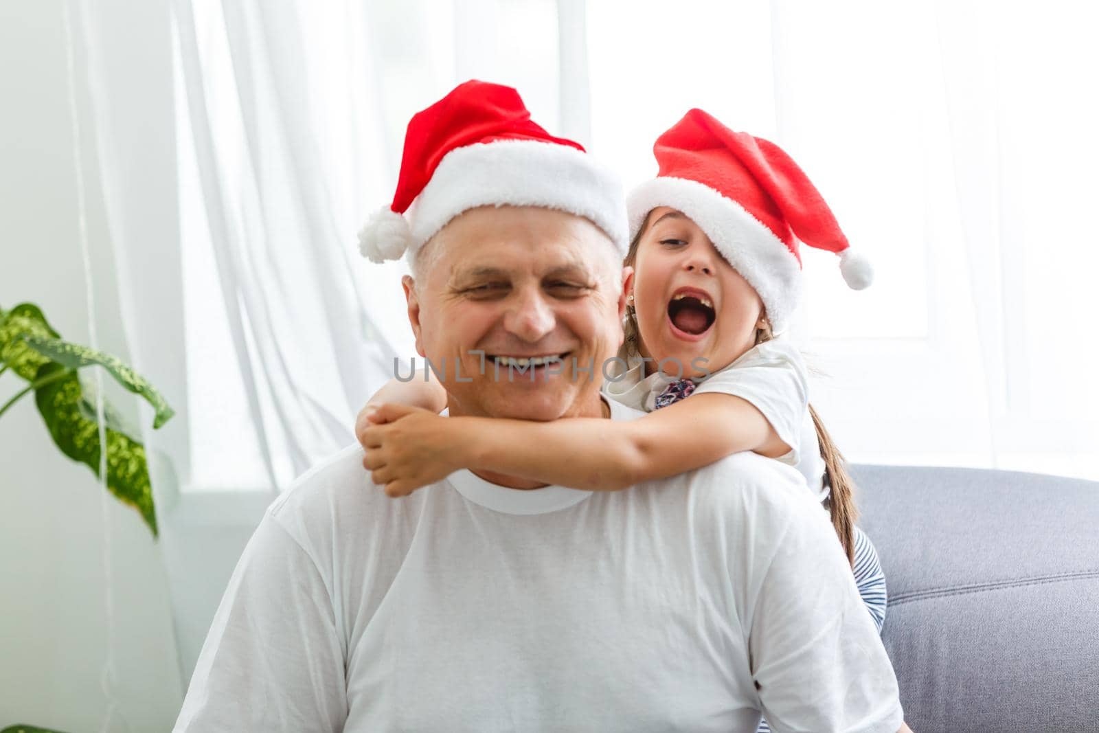 Happy childhood. Child enjoy christmas with Santa claus. Granddaughter spend time with grandpa. Christmas eve. Family. High quality photo