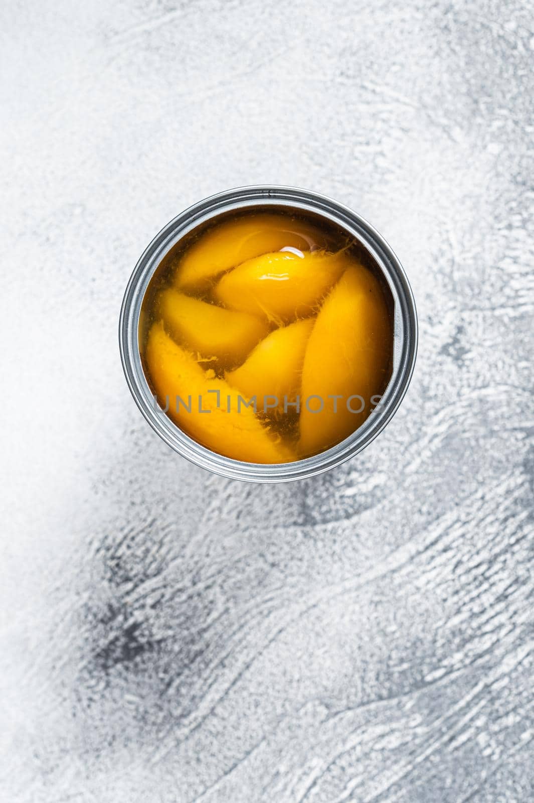 Canned mango slices in syrup in a metal can. White background. Top view by Composter