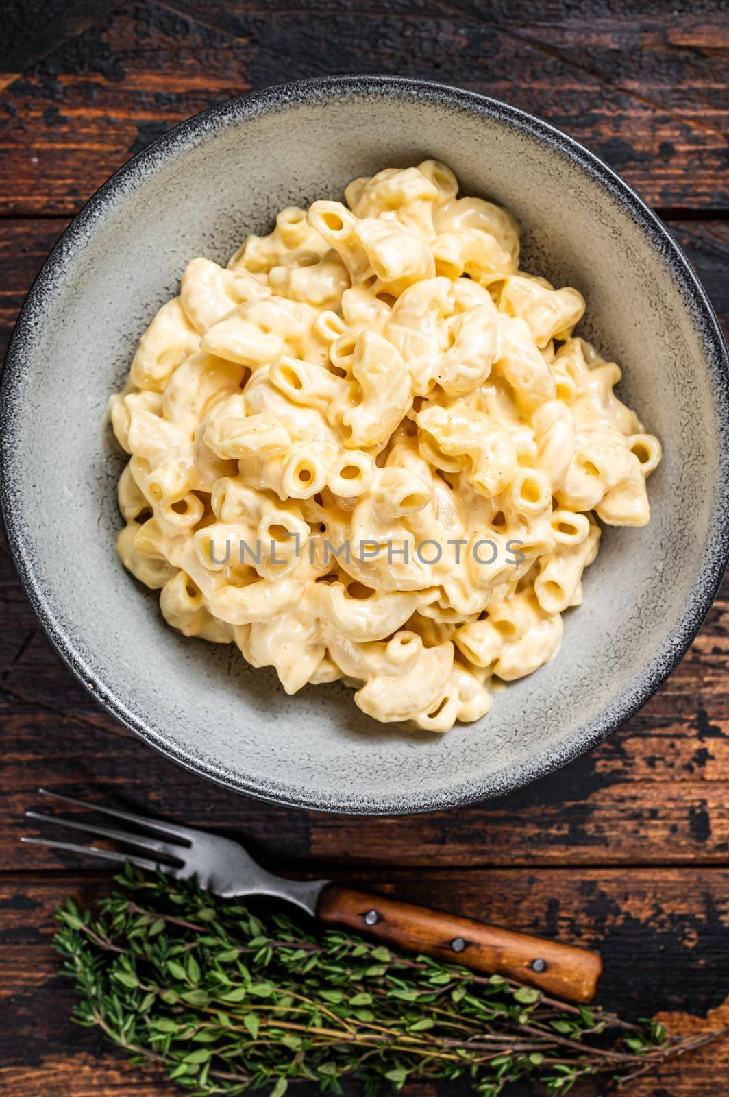 American dish Mac and cheese macaroni pasta with Cheddar. Dark wooden background. Top view by Composter