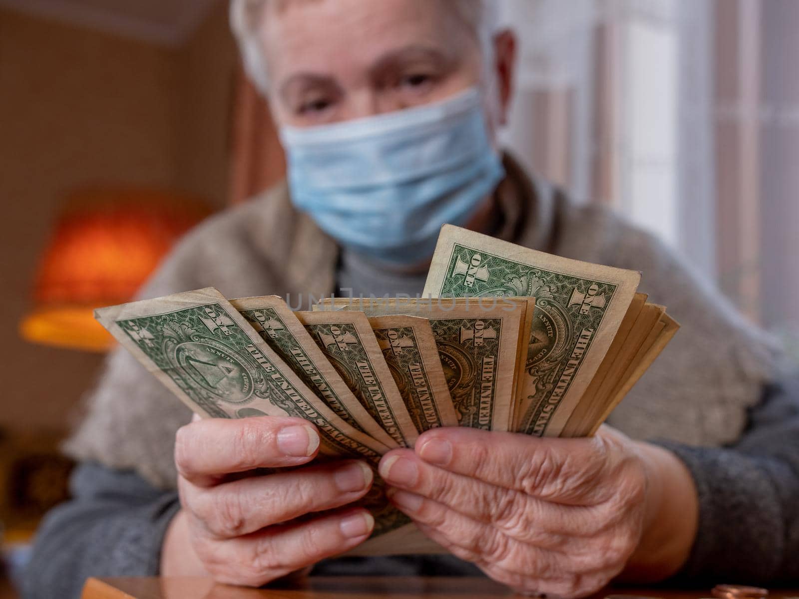 A woman with small bills in her hands counts the remaining savings. Economic crisis during the covid-19 pandemic.