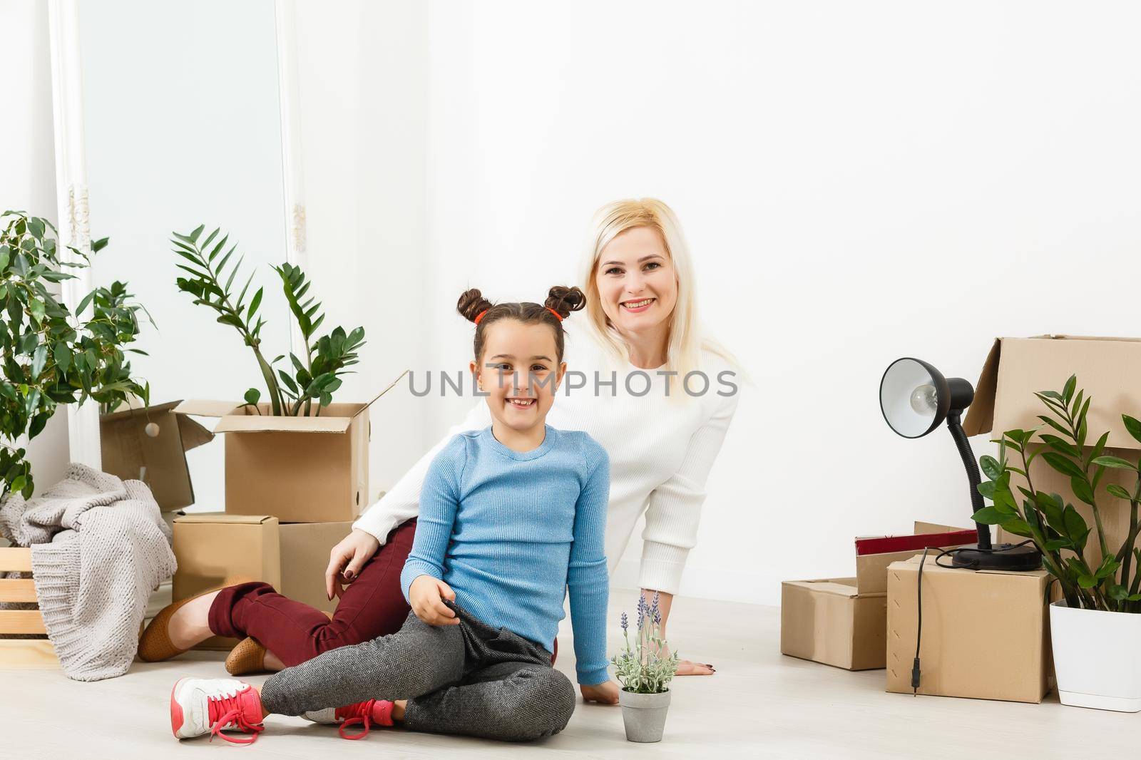 Family unpacking cardboard boxes at new home