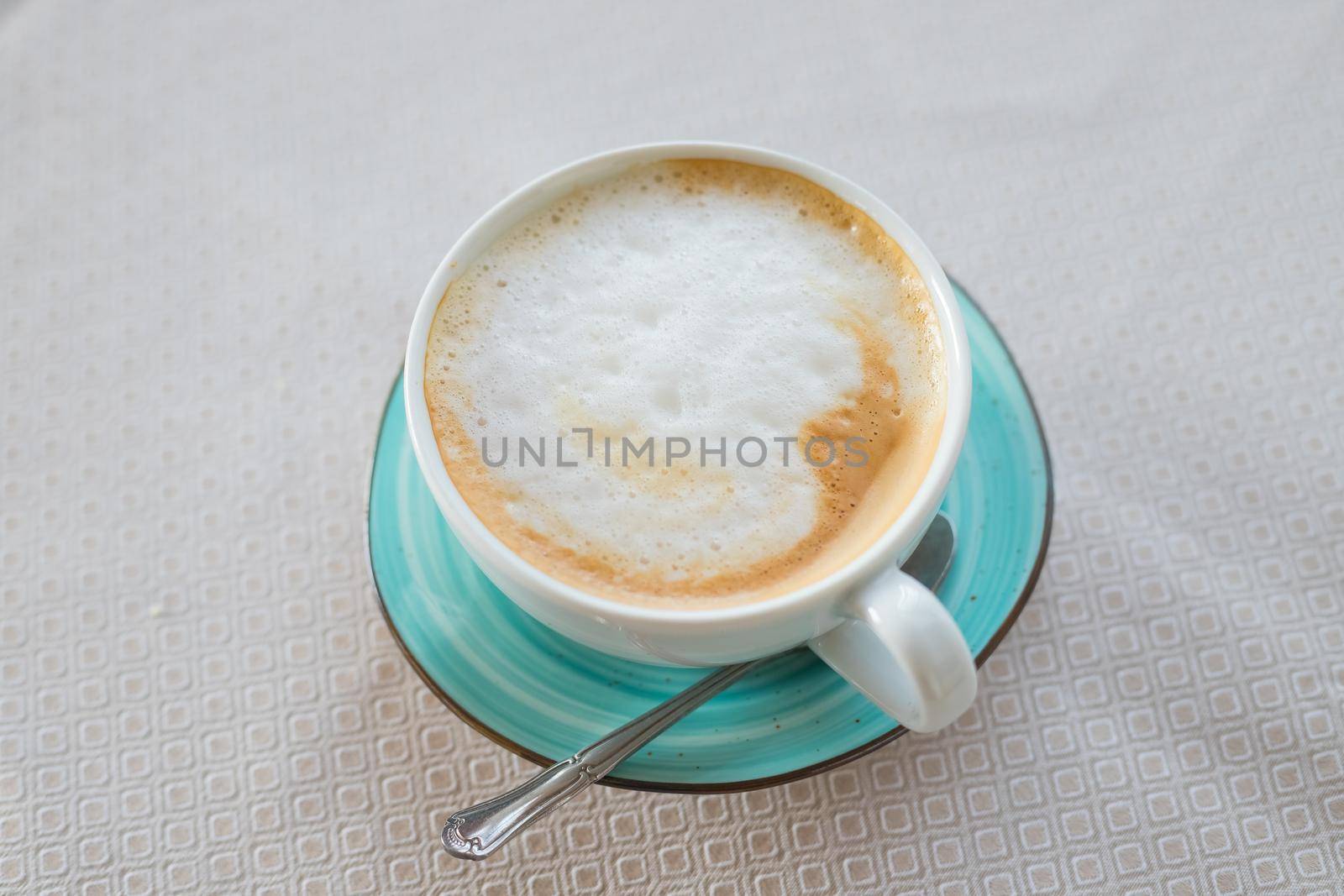 Hot coffee cappuccino latte art in jade color cup isolated