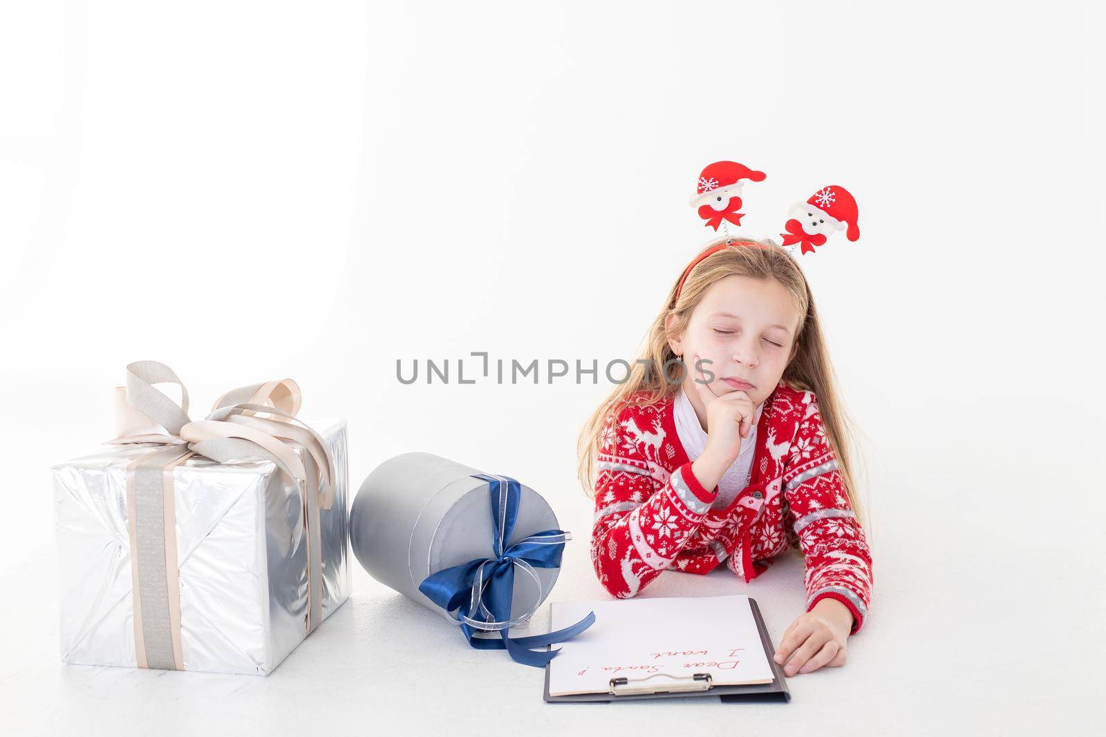 Christmas sale. Beautiful surprised child holding pen and writing.