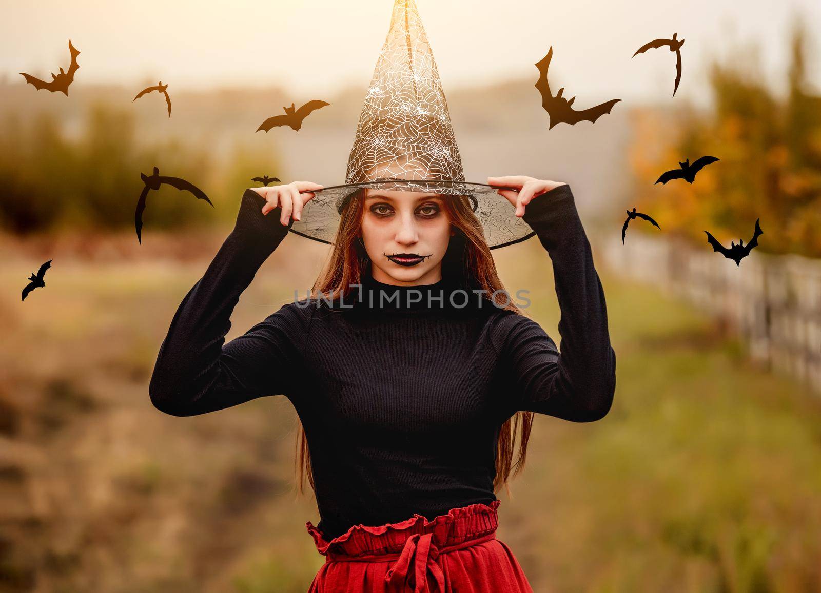 halloween portrait of teenage girl in witch hat with buts