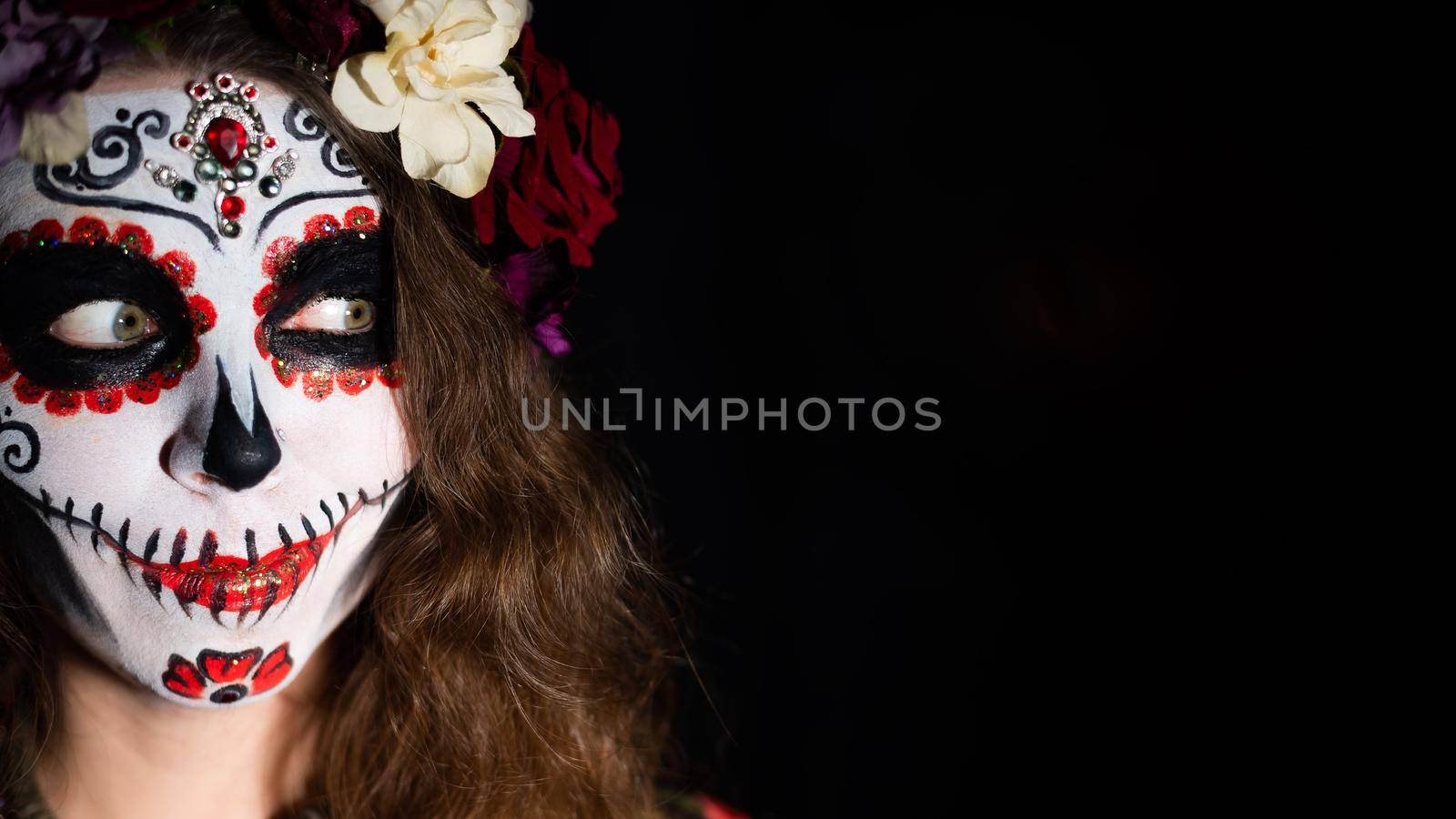 Woman in santa muerte makeup on a black background. Girl wearing traditional mexican holy death costume for halloween. Copy space by mrwed54