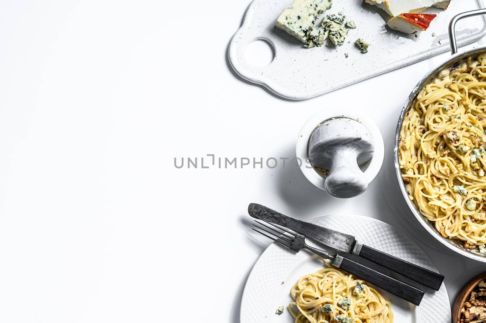 Spaghetti paste with cream blue cheese sauce and walnuts. Italian Home made food. Concept for a tasty, vegetarian dish. White background. Top view. Copy space by Composter