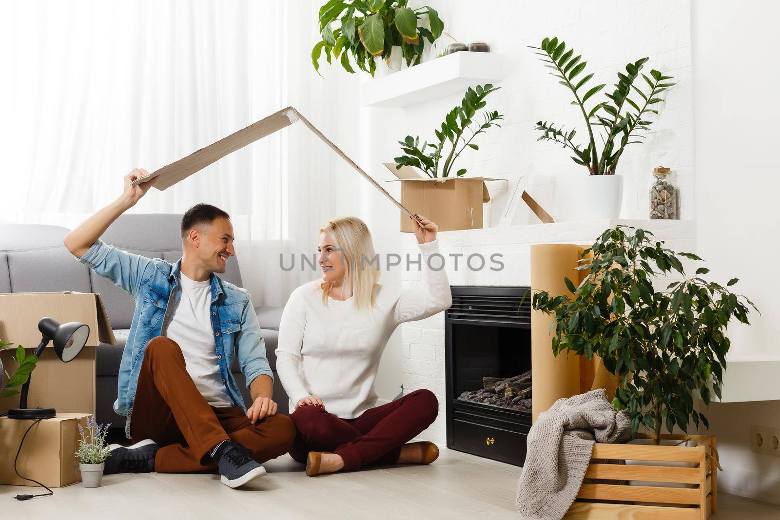 Young couple carrying big cardboard box at new home.Moving house.