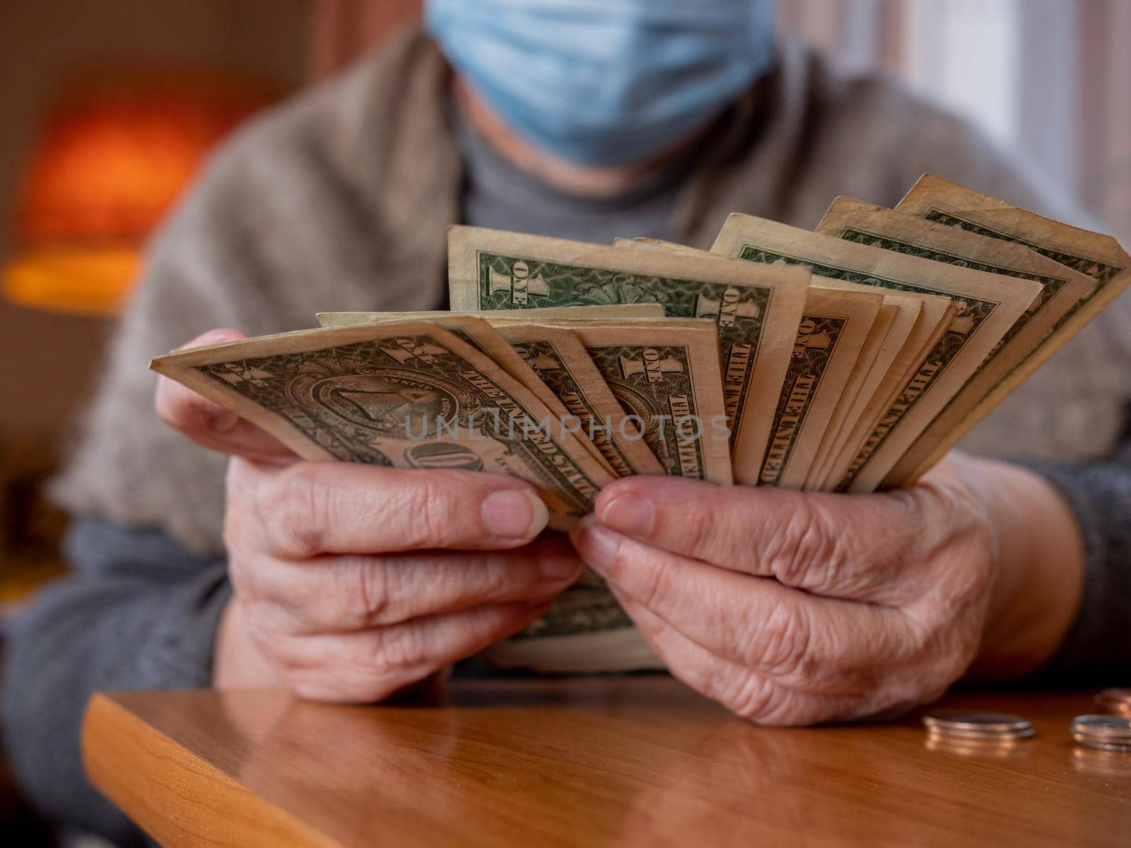 Economic crisis as a result of the covid pandemic. An elderly woman counts the last dollars.