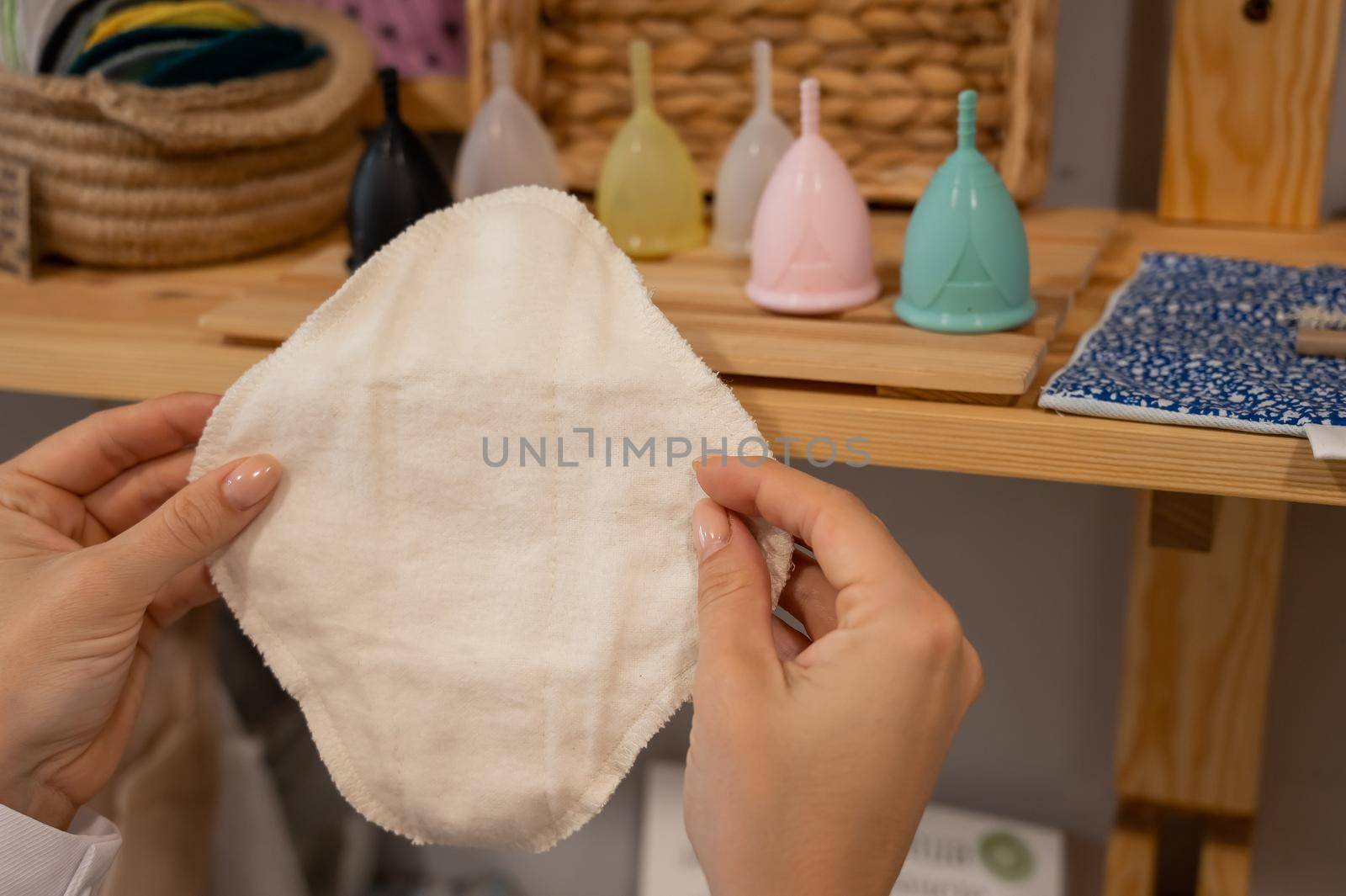 A woman in an eco store chooses a reusable pad. Intimate hygiene products.