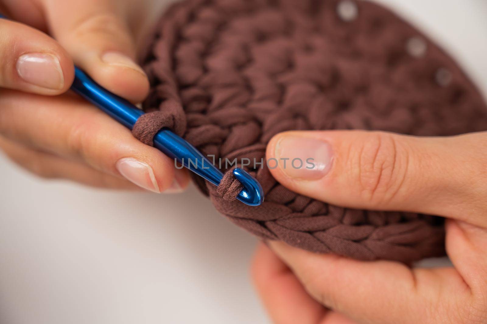 Close-up of a woman crocheting a basket of cotton yarn