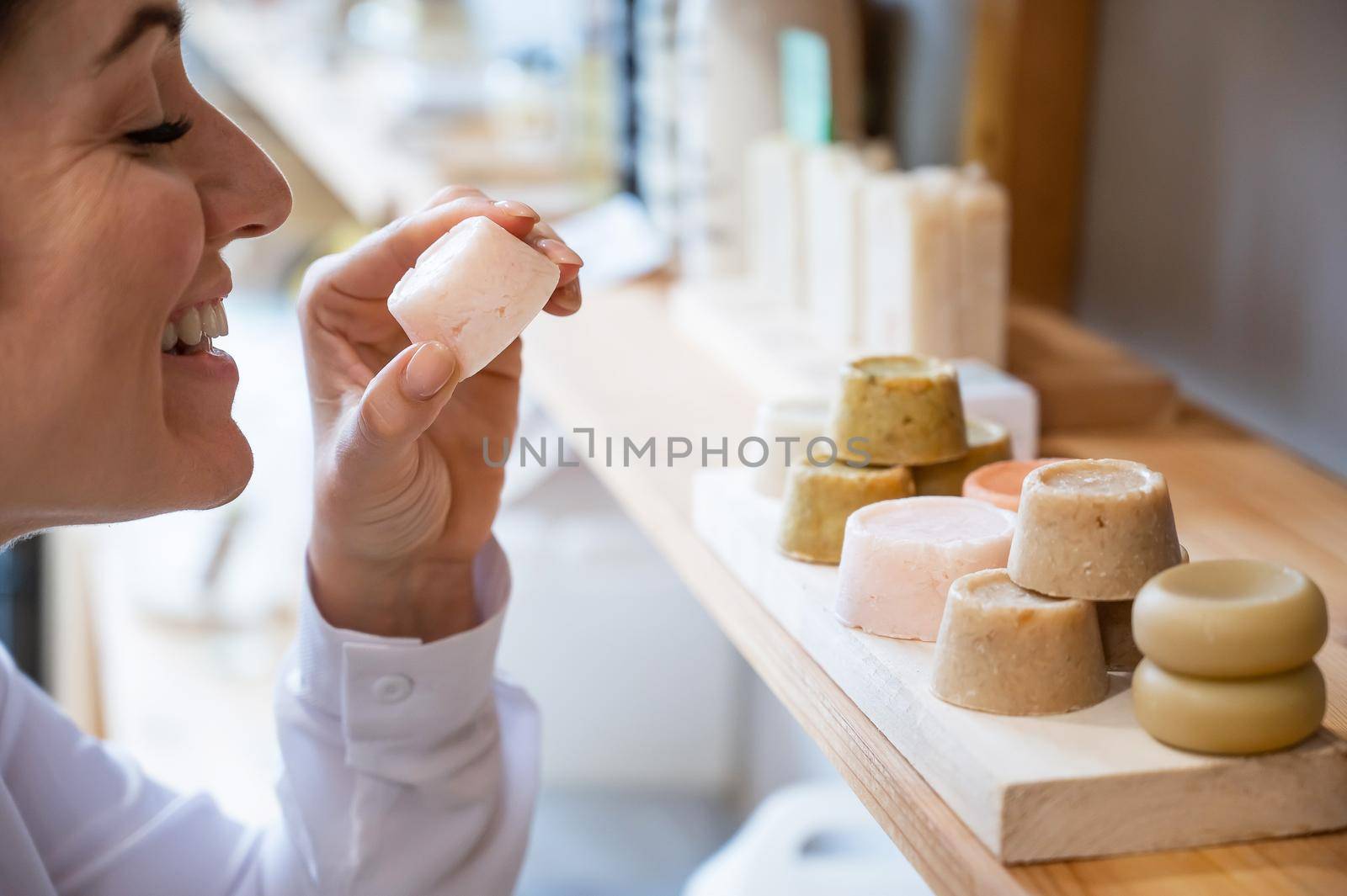 Woman sniffing organic soap while choosing at eco friendly store