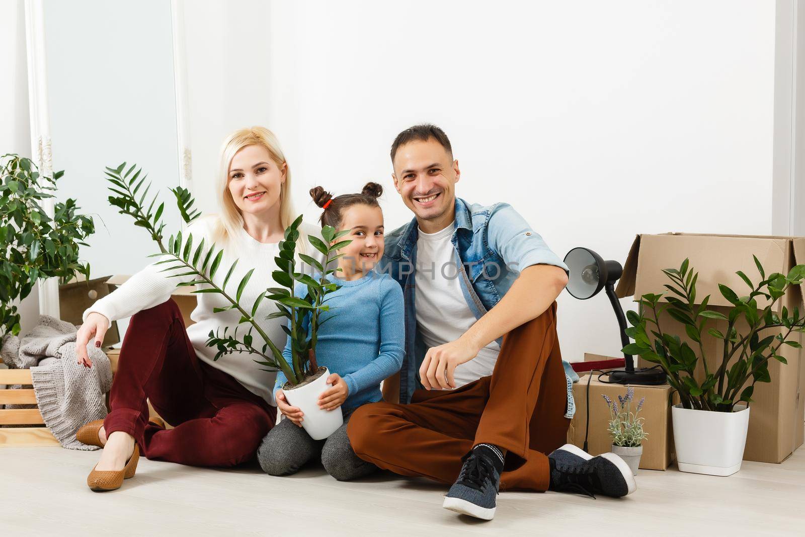 Family unpacking cardboard boxes at new home