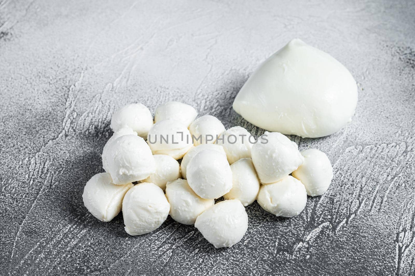 Mozzarella cheese mini balls on kitchen table. White background. Top view.
