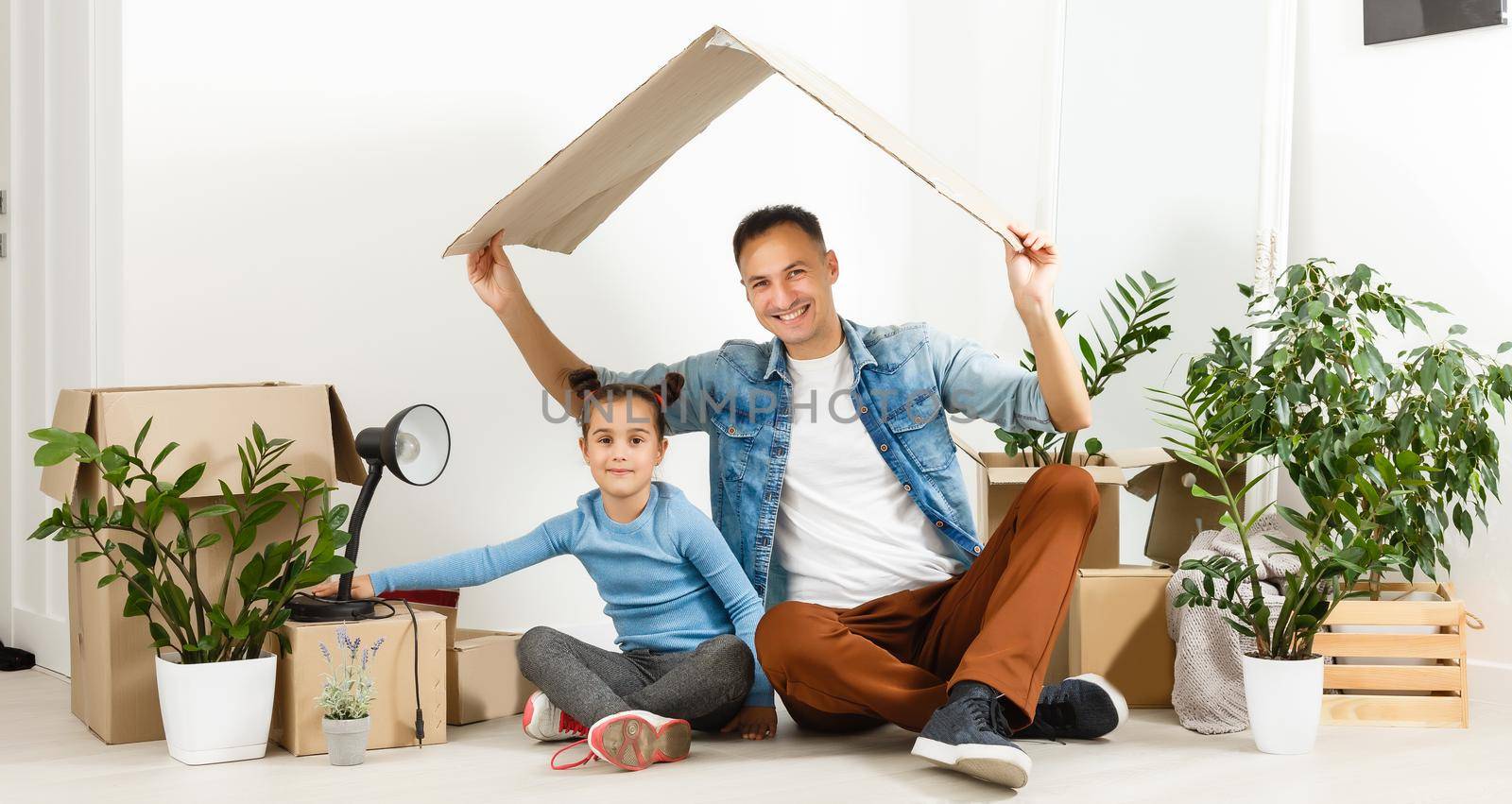 Family unpacking cardboard boxes at new home