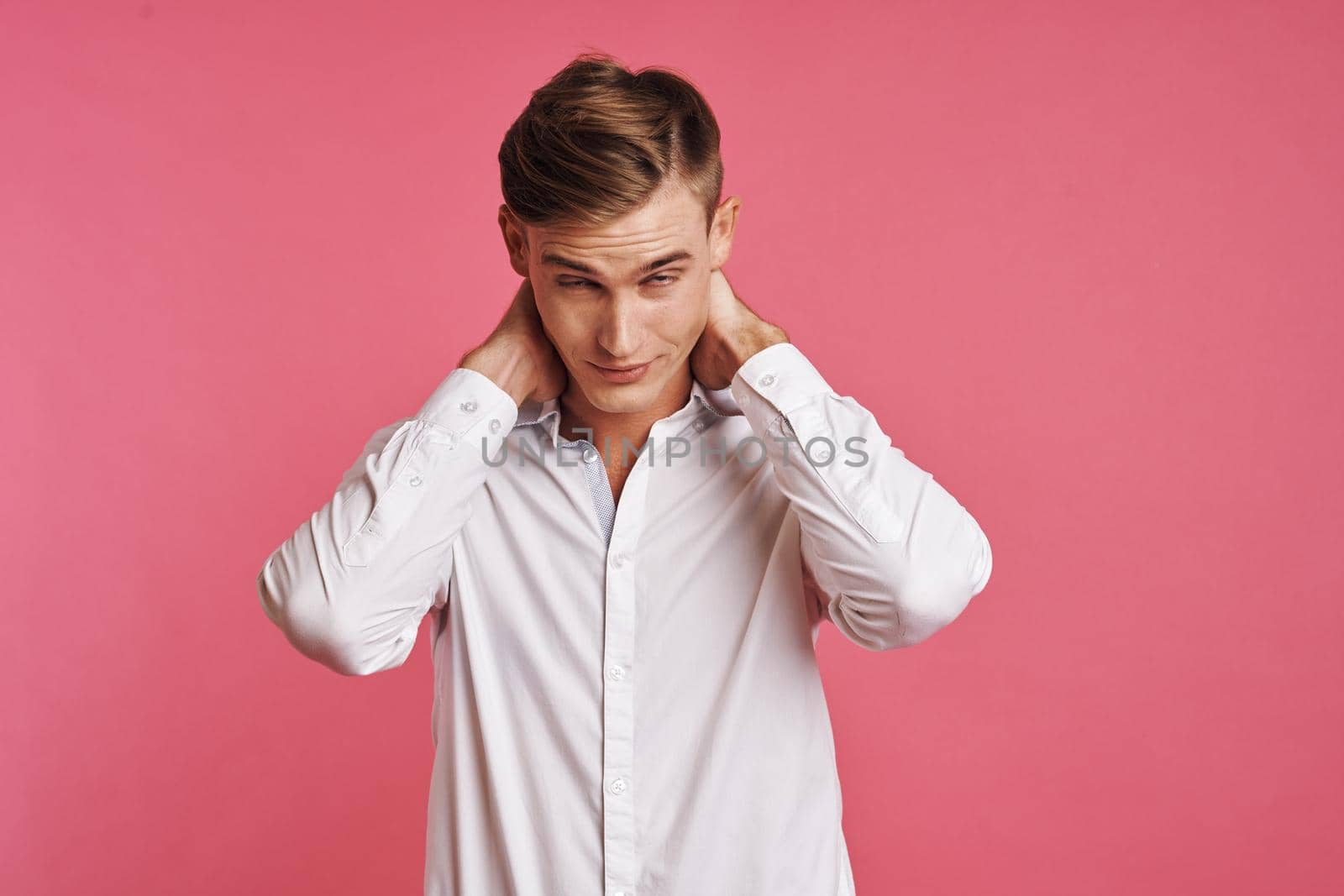 Young man in white shirt posing on pink background by Vichizh