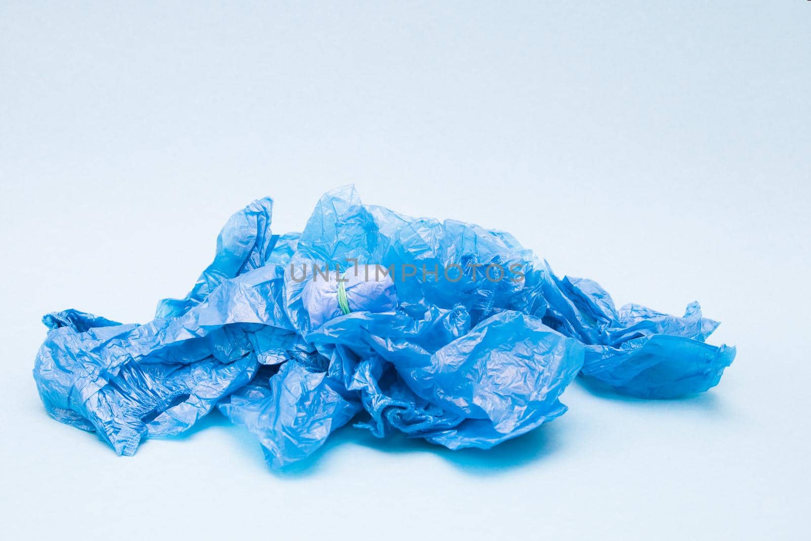 a lot of blue shoe covers on a blue background, copy space, a small bundle of shoe covers tied with an elastic band