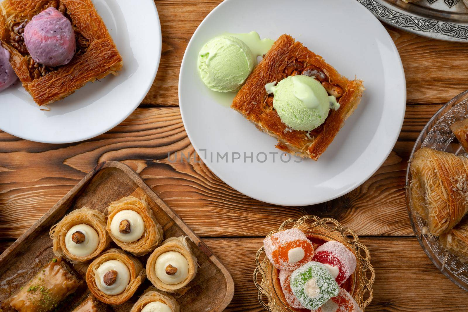 Turkish dessert kunefe served with ice cream on wooden background, close up