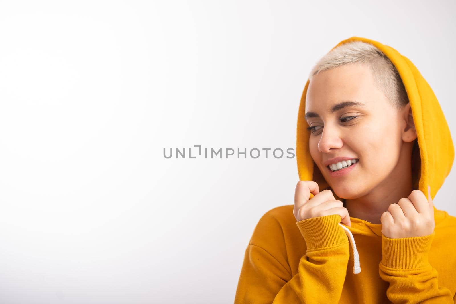Young woman in an ocher hood on a white background