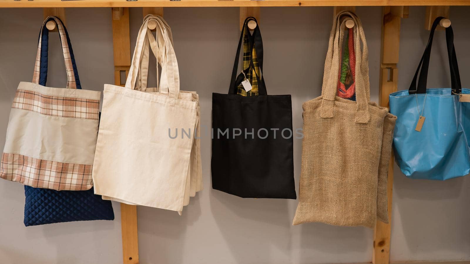 Choosing cotton bags in an eco-friendly store. by mrwed54