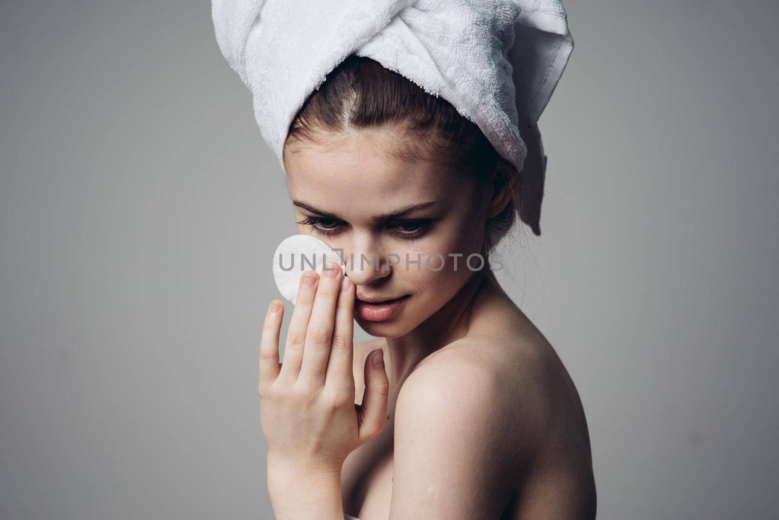 woman with cotton pads in her hands clean skin bare shoulders after shower by Vichizh