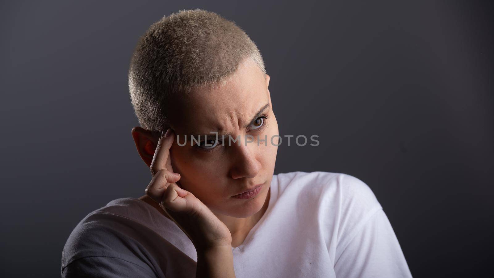 Portrait of pensive young woman with short hair on white background. Copy space.